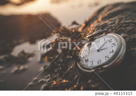Old clock on a rock by the ocean 40115315
