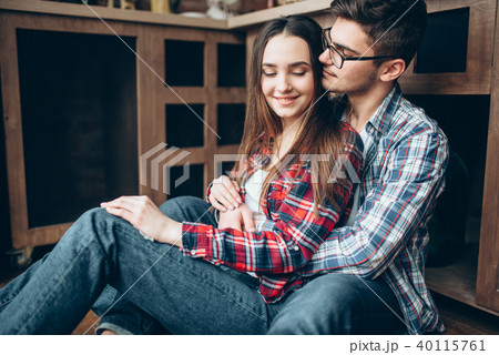 Love couple sitting on the kitchen floor and hugs Love couple sitting on the kitchen floor and hugs 40115761