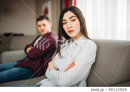 Wife sits on couch, angered husband yells on her 40115920