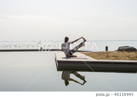 women on seaside meditating in yoga pose women on seaside meditating in yoga pose 40116995