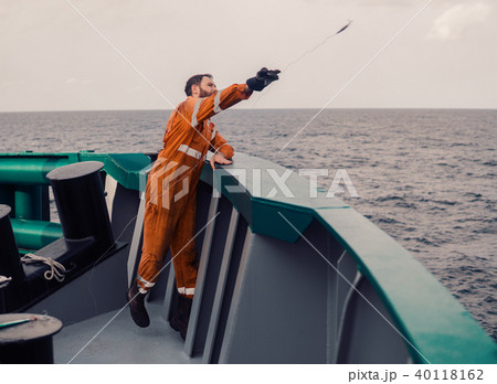 The fisherman throws a hook on a ship for catching tuna fish. Fishing at sea. The fisherman throws a hook on a ship for catching tuna fish. Fishing at sea. 40118162