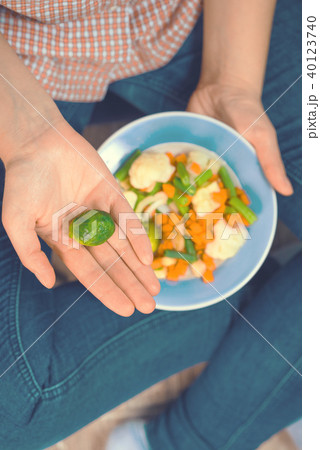 The girl holds a plate with vegetables 40123740