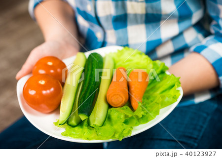 Girl with a plate of vegetables in hands 40123927