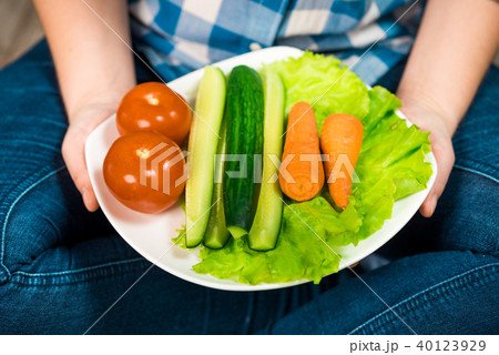 Girl with a plate of vegetables in hands Girl with a plate of vegetables in hands 40123929
