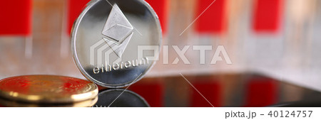 Silver ethereum coin is lying on cellphone 40124757