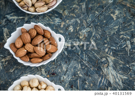 Pistachios, Almonds and Hazelnuts in White Bowls Pistachios, Almonds and Hazelnuts in White Bowls 40131569