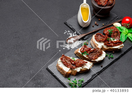 bruschetta with Canned Sundried or dried tomato halves on stone serving board 40133893