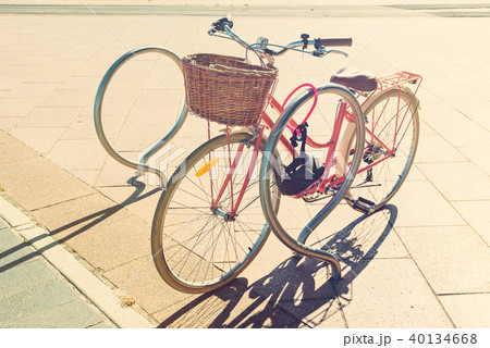 Pink vintage bicycle with basket on steering wheel 40134668