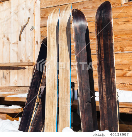 wide forest skis near door of wooden cottage 40138997