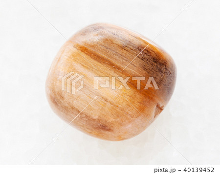 tumbled brown tiger's eye gem on white marble tumbled brown tiger's eye gem on white marble 40139452