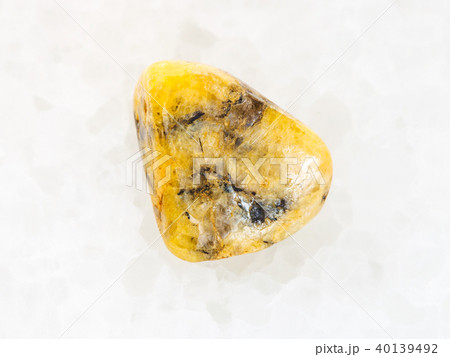 tumbled yellow Agate gemstone on white marble 40139492