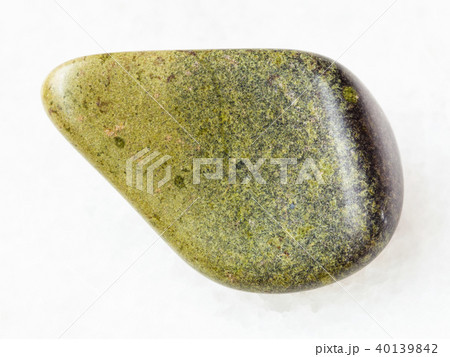 tumbled epidote gemstone on white marble 40139842