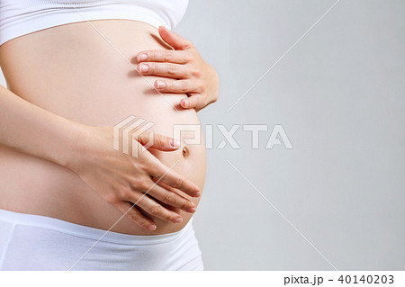 Young pregnant woman caress belly. 40140203