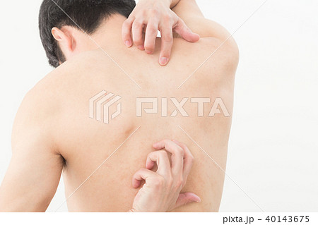 背中を掻く男性の写真素材