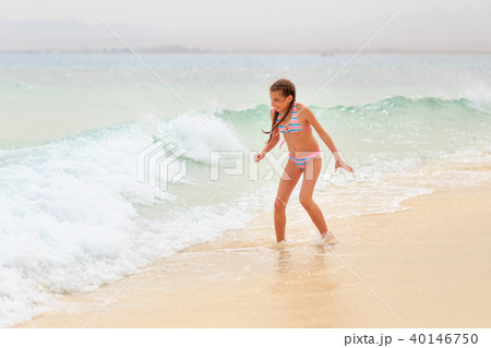 Young teenage girl having fun with waves on beach 40146750