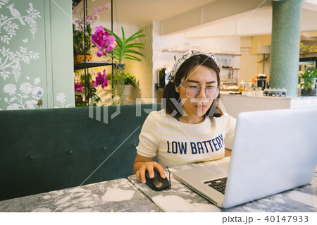 Woman using laptop while sitting at cafe. Woman using laptop while sitting at cafe. 40147933