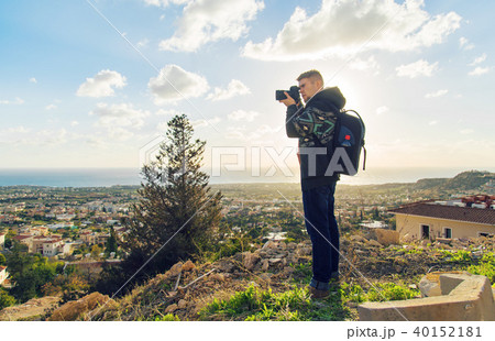 Young photographer with backpack making photos of sea and rocks with the camera. Mediterranean sea 40152181