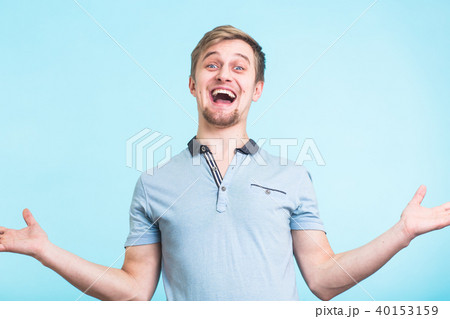 Excited man exclaimed in happiness, gestures actively, expressed great surprisement, over blue 40153159