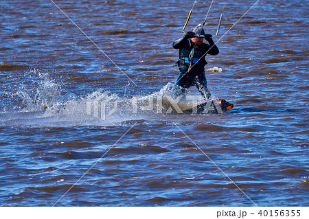Male kiteboarder rides on a board along the river Male kiteboarder rides on a board along the river 40156355