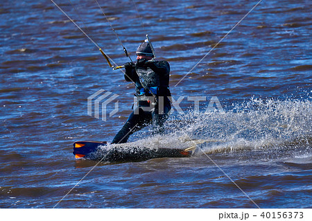 Male kiteboarder rides on a board along the river Male kiteboarder rides on a board along the river 40156373