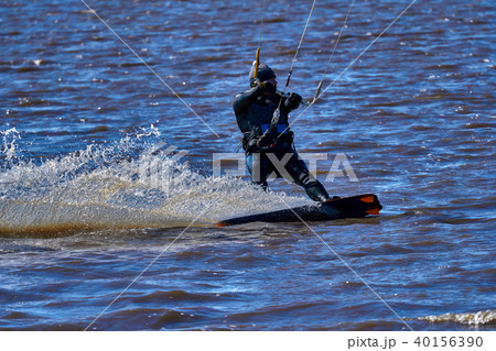 Male kiteboarder rides on a board along the river Male kiteboarder rides on a board along the river 40156390