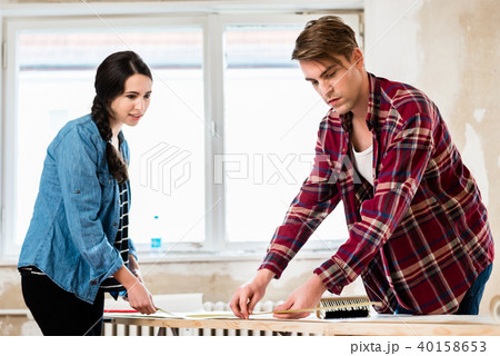 Young couple sharing tools while working on improvement of their house 40158653