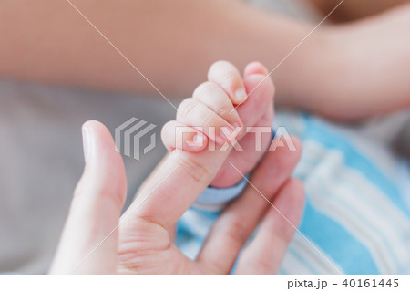 Newborn baby holding his mother finger.  40161445