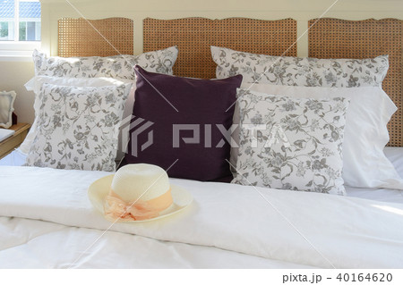 vintage bedroom with hat and flower pillows on bed 40164620