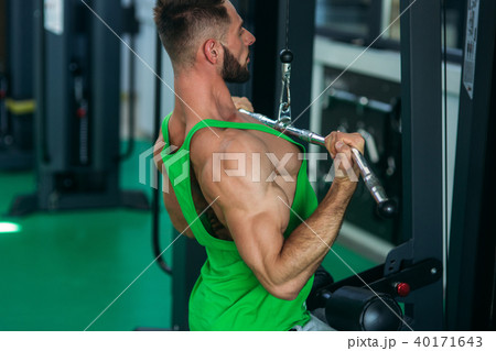 A young athlete trains in the gym. Bodybuilder trains the muscules of the back A young athlete trains in the gym. Bodybuilder trains the muscules of the back 40171643