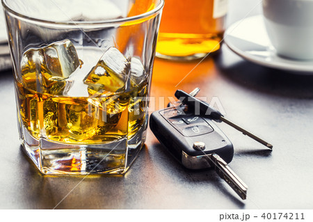 Car keys and glass of alcohol on table. Car keys and glass of alcohol on table. 40174211