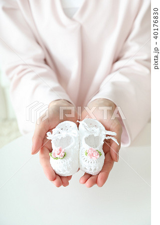 ベビーシューズを差し出す女性 40176830