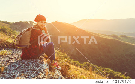 Woman tourist at top of mountain at sunset outdoors during  hike 40179170