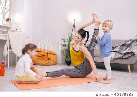 Happy mother training and kids helping her 40179338