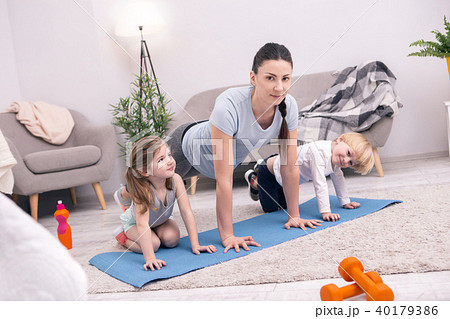 Loving mother doing push-ups with her kids Loving mother doing push-ups with her kids 40179386