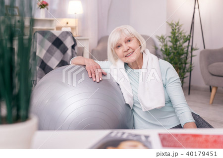 Cute elderly woman leaning on yoga ball and smiling 40179451