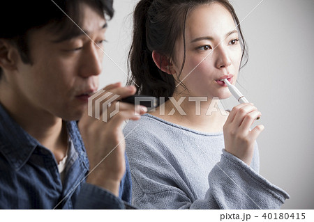 加熱式タバコを吸う男女 40180415