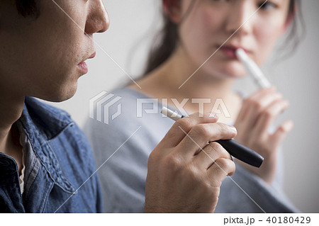 加熱式タバコを吸う男女 40180429