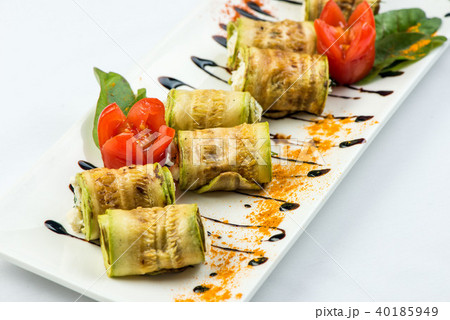 Grilled zucchini roll with a stuffing on a white plate on a white background Grilled zucchini roll with a stuffing on a white plate on a white background 40185949