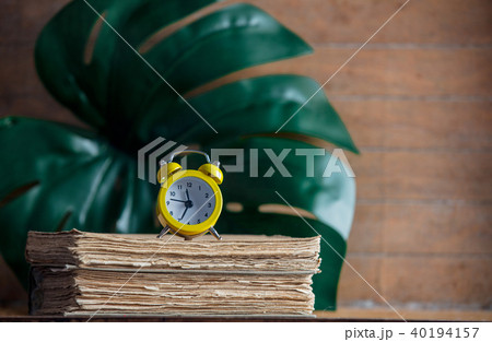 Little alarm clock and books with palm leaf Little alarm clock and books with palm leaf 40194157