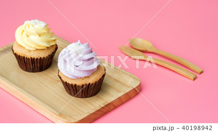 Cupcake on a wooden plate and pink background. 40198942