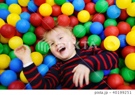 Happy little boy having fun in ball pit with colorful balls Happy little boy having fun in ball pit with colorful balls 40199251