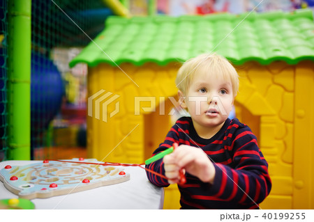 Happy little boy having fun with educational toy in play center Happy little boy having fun with educational toy in play center 40199255