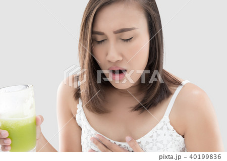 Asian woman is squeamish from the juice against gray background. Asian woman is squeamish from the juice against gray background. 40199836