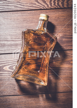 Bottle of whiskey on wooden table Bottle of whiskey on wooden table 40200244