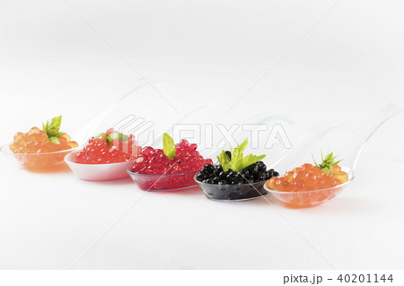 Plastic spoons with fish caviar on a white backgro 40201144