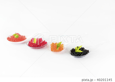Plastic spoons with fish caviar on a white backgro 40201145