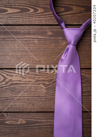 Purple necktie on wooden table Purple necktie on wooden table 40207204