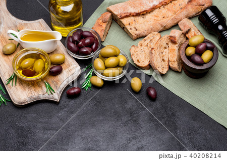 black and green olives, bread and n wooden cutting board 40208214