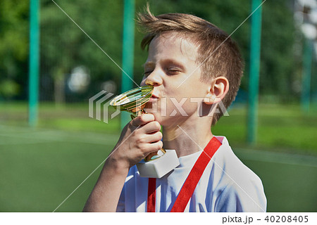 Winner boy football player kisses cup Winner boy football player kisses cup 40208405