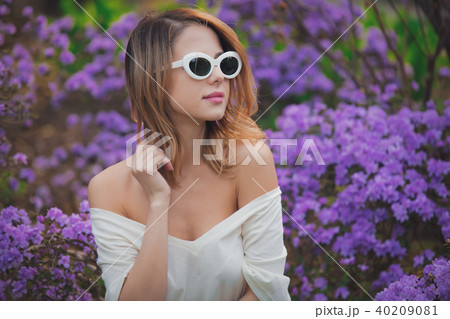 girl in white sunglasses near purple flowers 40209081